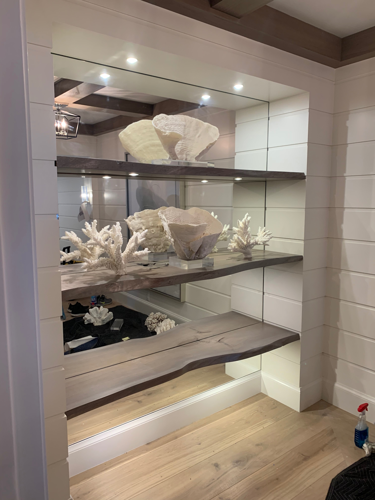 Mirrored display niche with live-edge walnut floating shelves and shiplap paneling
