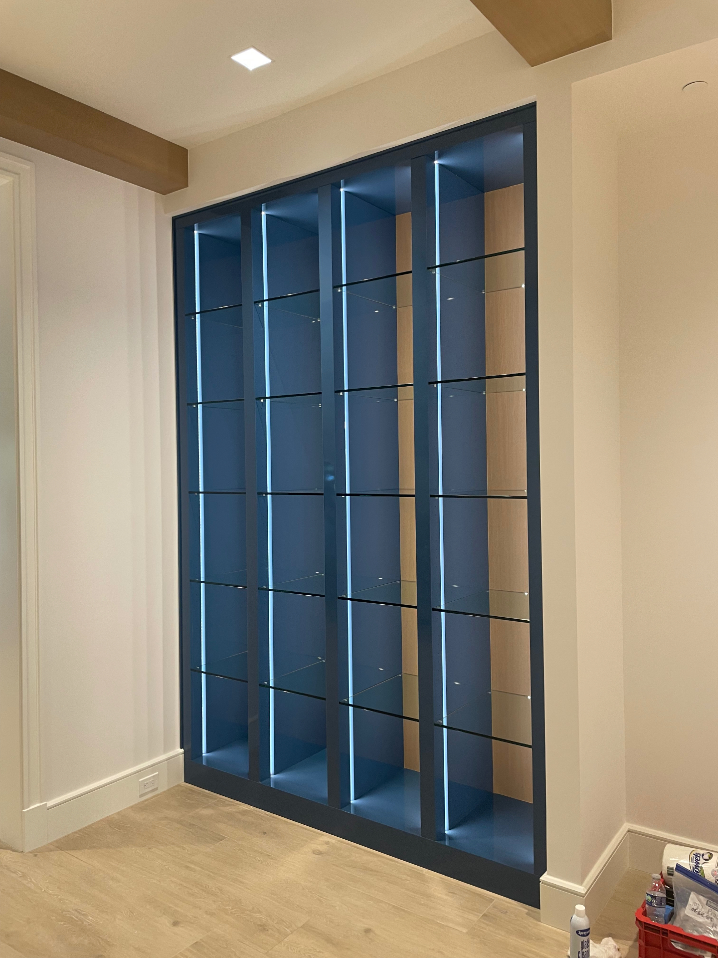 Illuminated display cabinet with glass shelves and concealed linear lighting by ARTEC Woodworkers