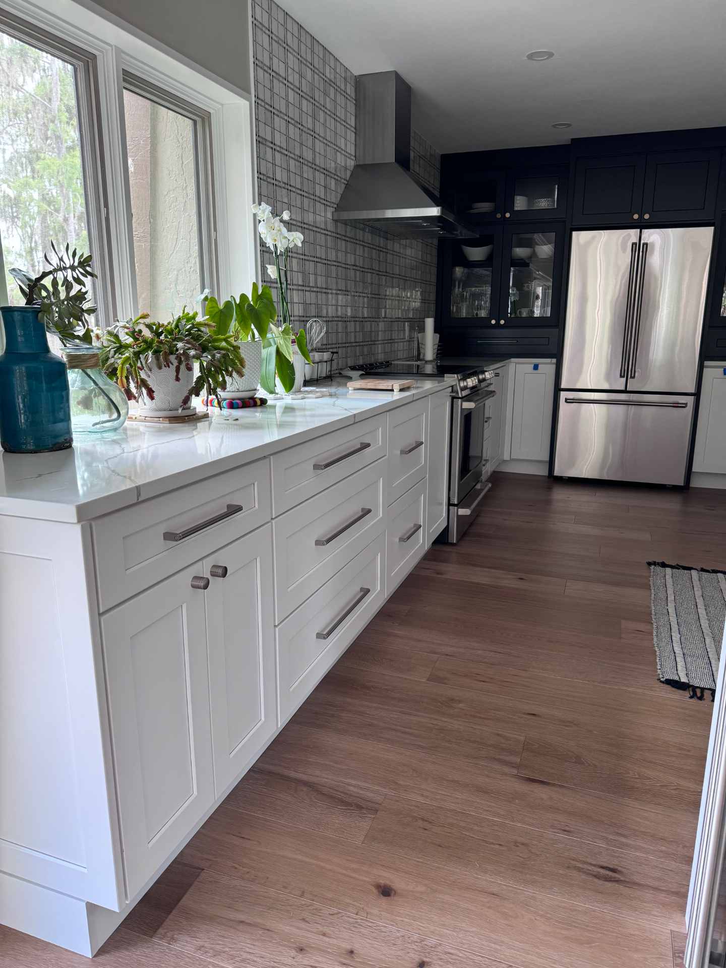 Kitchen with white shaker base cabinetry, quartz countertop and navy upper cabinetry